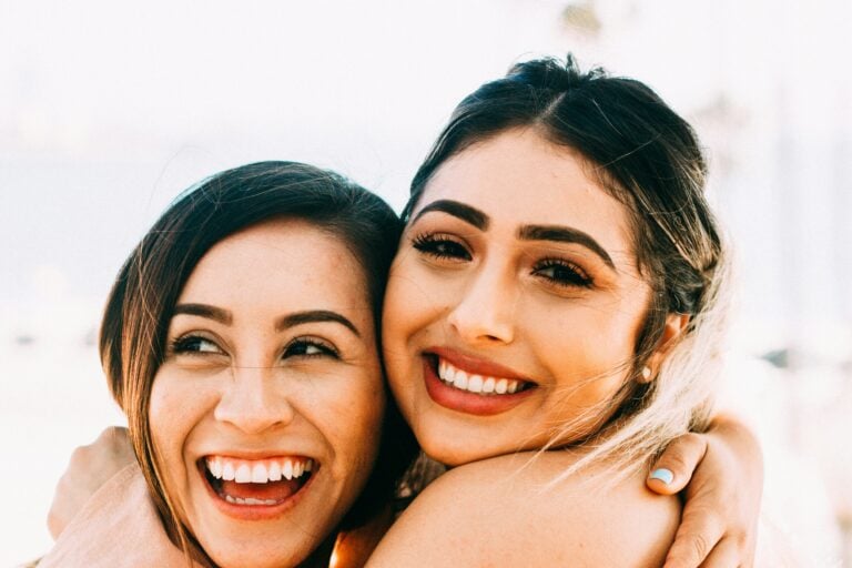 Two smiling women hugging, showcasing their close friendship with bright expressions, perfect for illustrating a blog post about friendship captions for Instagram.